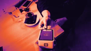 A customer paying by card at a payment terminal, in Arcsen colours