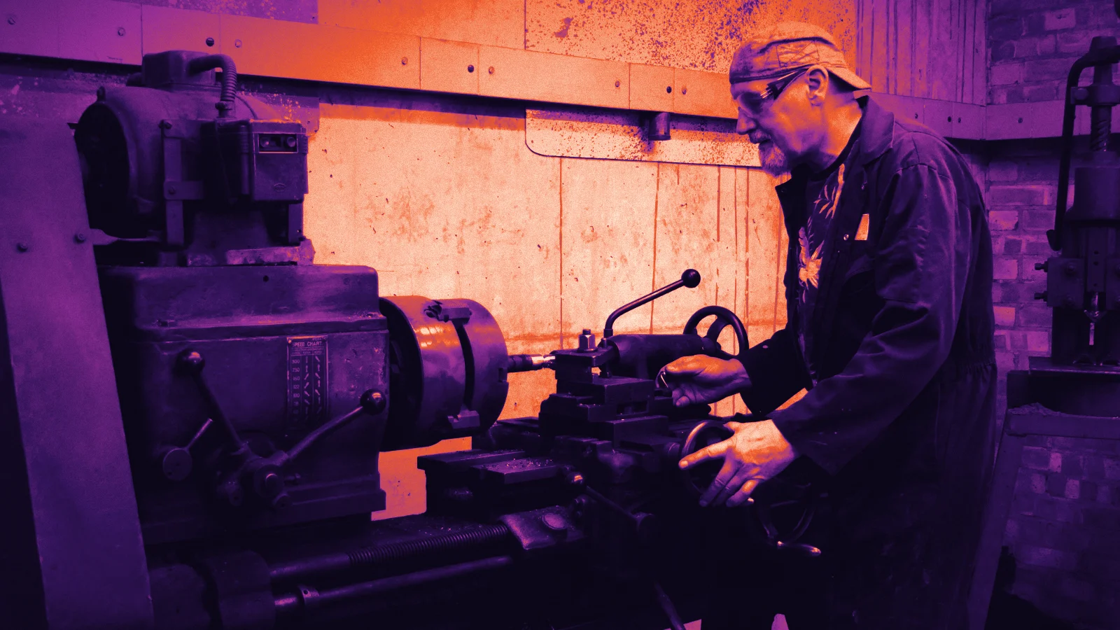 A technician working on a machine in a factory, in Arcsen colours
